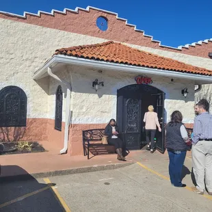a group of people standing outside a restaurant
