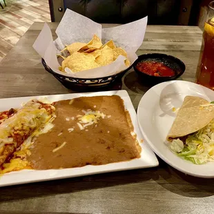 Enchilada and taco with refried beans.  All meals come with chips and salsa.