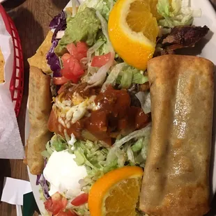 Tamale Deluxe. It&apos;s a tamale with two flautas laying over a nacho deluxe.