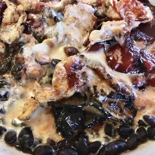 The El Vaquero Bowl includes chicken, a variety of grilled veggies, and queso over black beans (or rice).