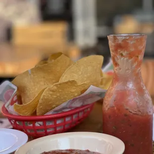 a table with chips and salsa