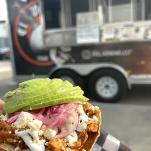 a person holding up a sandwich