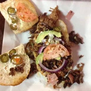 Torta Cubana, chorizo,carnitas,milanesa,ham,refried beans,lettuce,avacado,onion,jalapeno and mayo $7.99