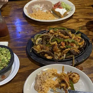 Steak shrimp and chicken Fajitas with fresh veggies and guacamole