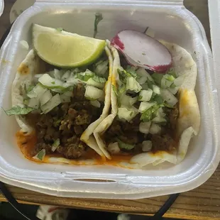 two tacos in a styrofoam container