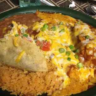 Tamal, enchilada taco beans and rice in an ocean of cheese and sauce