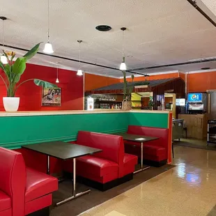 a restaurant with red and green booths