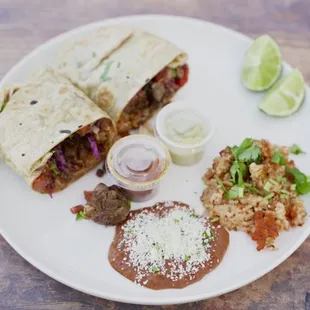 Steak burrito, with side of refried beans and red rice.
