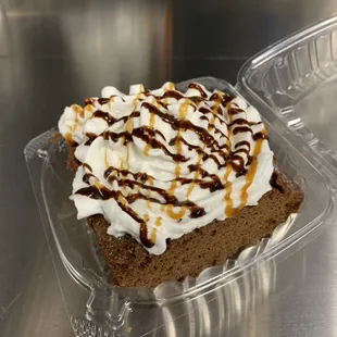 Chocolate Tres Leches Cake topped with whipping cream and drizzled with chocolate and caramel syrup.