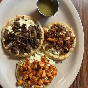 Picadita topped with chicken, pastor-pork, and asada-beef and all with cheese. The dough is not fried so it's healthy. Quite delicious.
