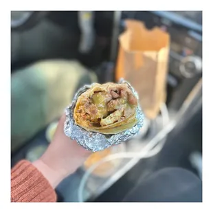 a hand holding a burrito