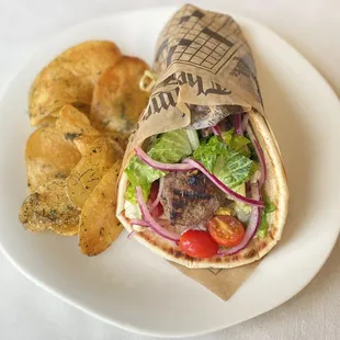 Steak Kabab sandwich with tahini sauce served with our herbed house chips