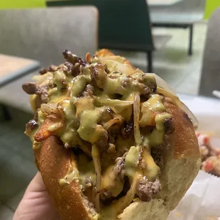 Close up of the Philly cheesesteak-- lots of meat and there's fries in there, too.