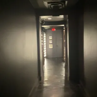 a dark hallway with a red light