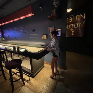 a woman standing in front of a bar