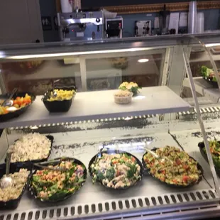 a variety of salads in a display case