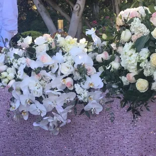 Head table flowers for a wedding. The side ones were suppose to go on candelabra but the table wasn't stable since it was on grass
