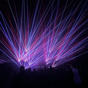 a crowd of people watching laser lights