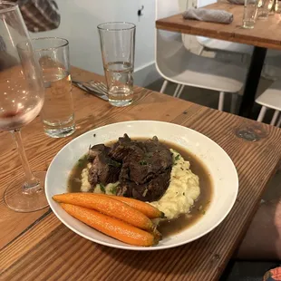 a bowl of beef and mashed potatoes with carrots