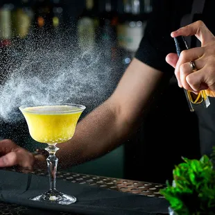 a bartender pouring a cocktail