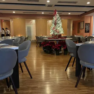 a dining room with a christmas tree in the background