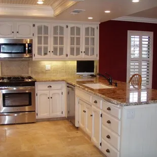 a kitchen with white cabinets and granite countertops