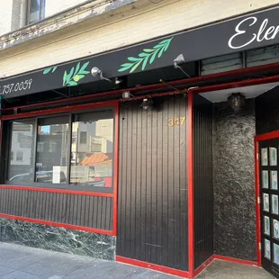 the front of a restaurant with a red door
