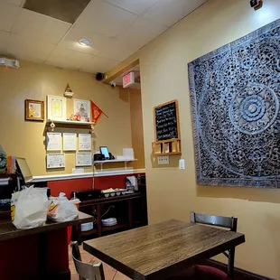 a restaurant with a large tapestry hanging on the wall