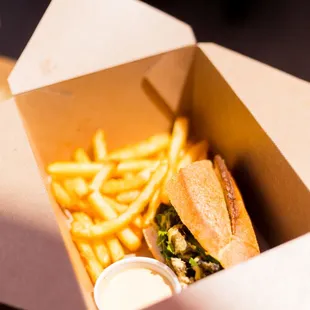 a sandwich and fries in a box