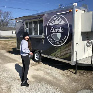 a woman standing in front of a food truck