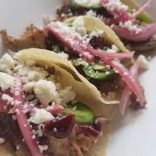 Duck tacos-- made with berry gastrique, jalapeños, pickled onions, queso fresco