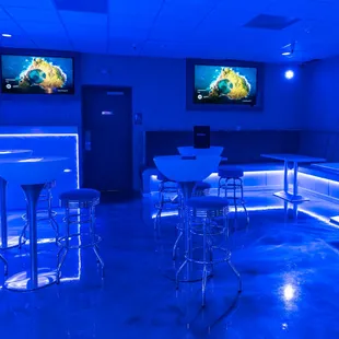 a bar with blue lighting and bar stools