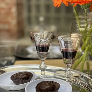 a glass of wine and two cupcakes