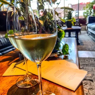 a glass of white wine on a table