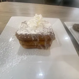a square white plate with a pastry on it