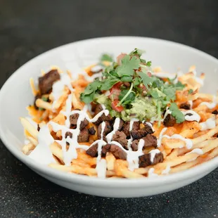 a bowl of fries topped with toppings
