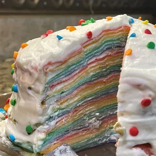 30 Layer Rainbow Crepe Cake. It is 30 layers of colorful crepes with a whipped frosting and sprinkles.