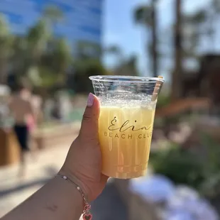 a hand holding a drink