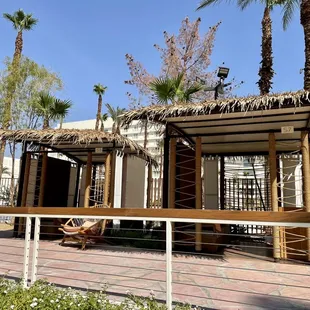 a beach cabana with palm trees in the background