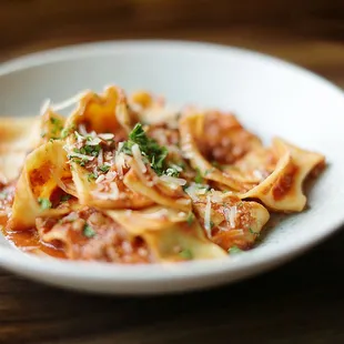 a bowl of pasta on a wooden table