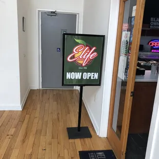 a sign for elife now open