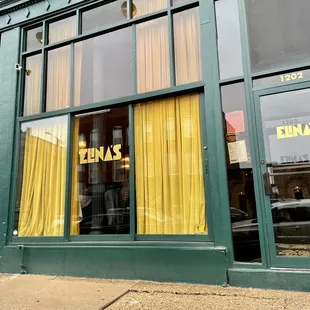 a storefront with yellow curtains