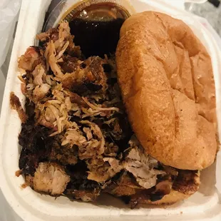 a pulled pork sandwich in a styrofoam container