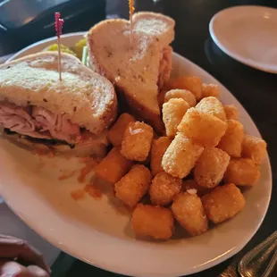 Turkey bacon avocado sandwich with tots.