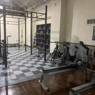 Functional training area with rowing machines, spin bikes, and an air assault bike.