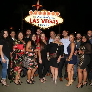a group of people posing in front of a welcome sign