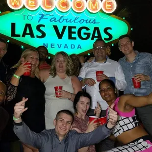 a group of people posing in front of a welcome sign