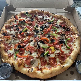 Large Supreme Pizza with sides of Parmesan and Crushed red pepper flakes