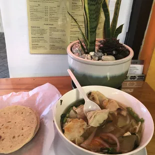 a bowl of soup and a tortilla