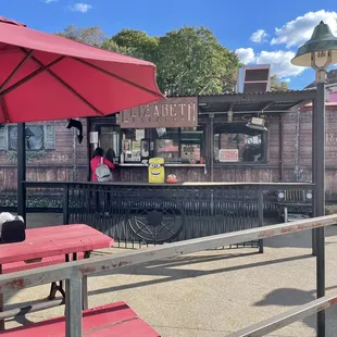 a red picnic table with a red umbrella
